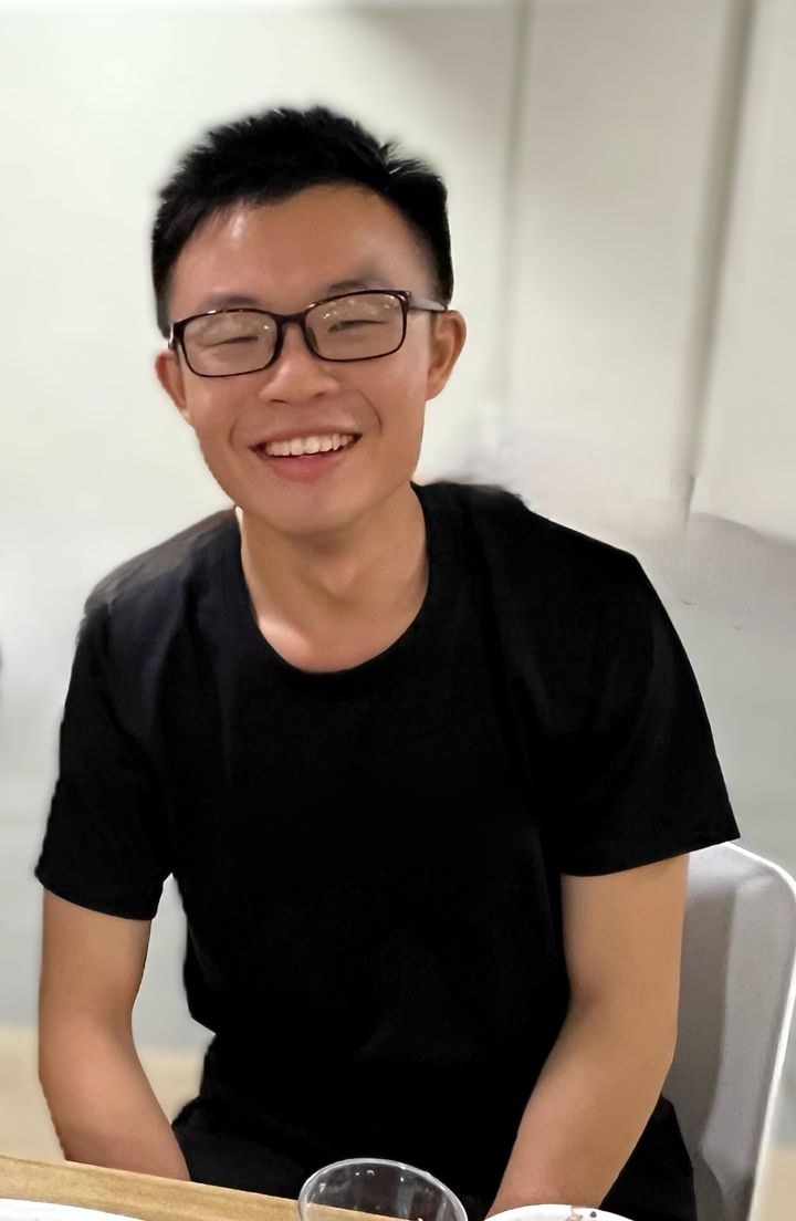 Chuan Long, smiling, in a black T-shirt